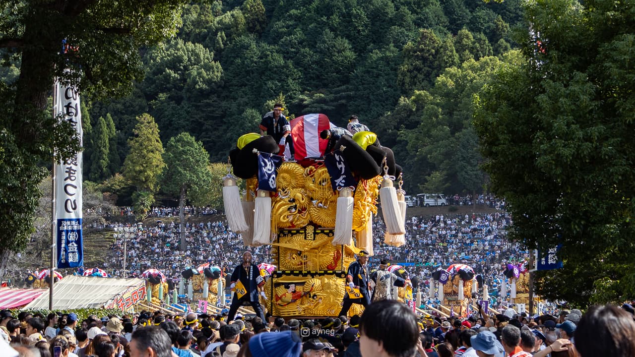 Golden taiko float standing before massive crowd
