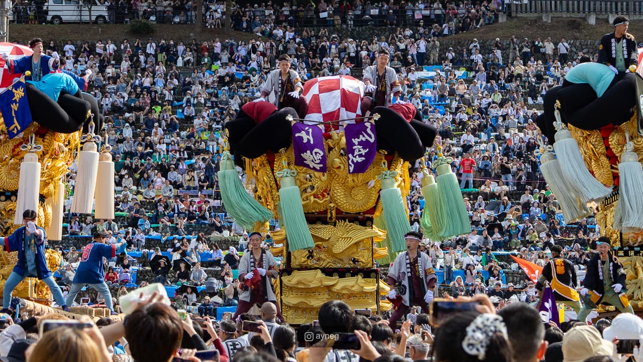 Multiple taiko floats surrounded by spectator stands
