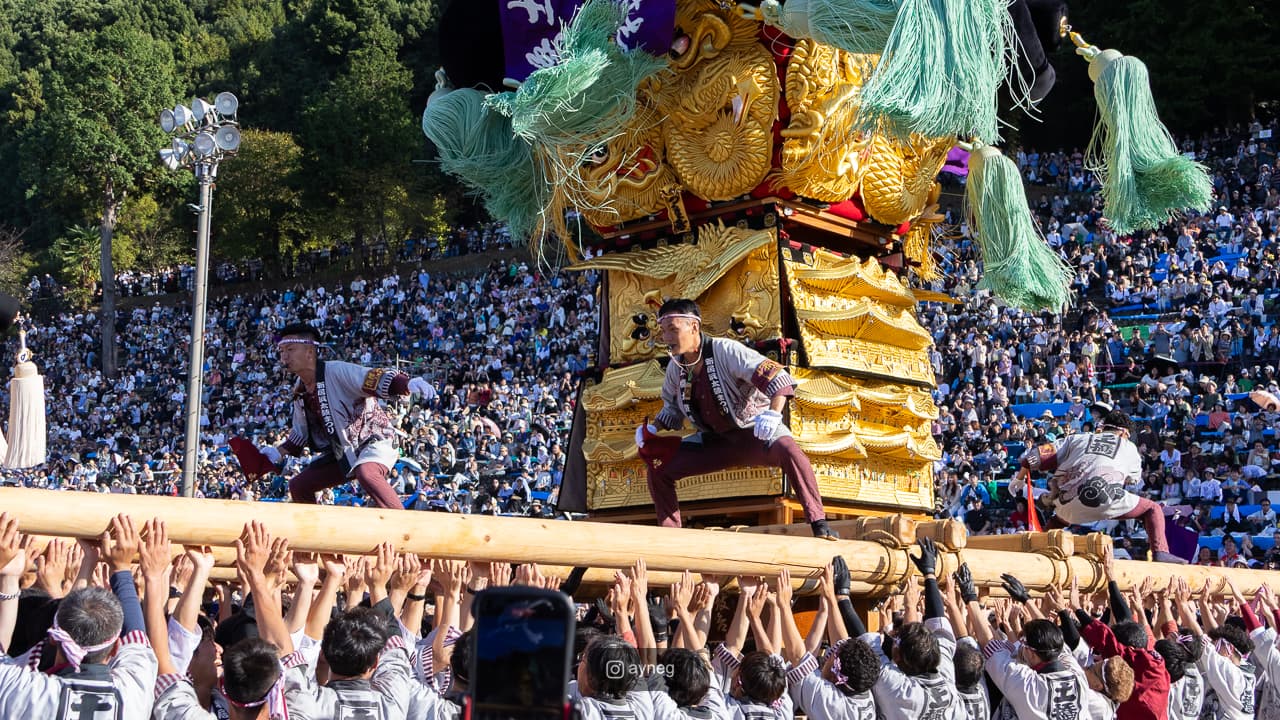 View from below of numerous bearers carrying taiko float